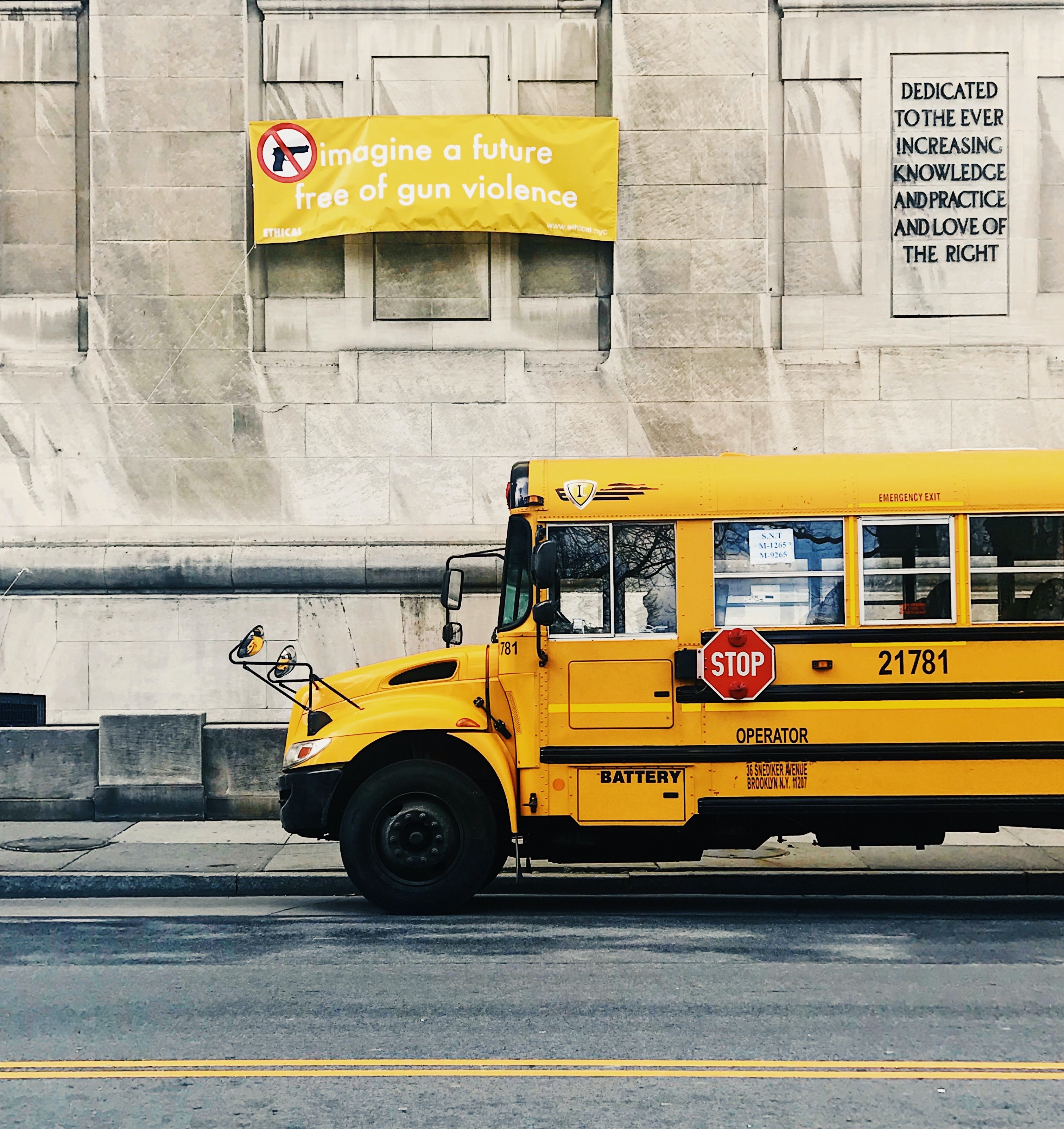 school bus drives past anti-gun sign